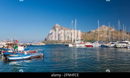 San Vito Lo Capo, Trapani, Sizilien, Italien. Panoramablick über den farbenfrohen Hafen auf die hoch aufragenden Gipfel des Monte Monaco und des Pizzo di Sella. Stockfoto