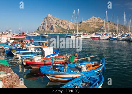 San Vito Lo Capo, Trapani, Sizilien, Italien. Blick über den farbenfrohen Hafen auf die hohen Gipfel des Monte Monaco und des Pizzo di Sella. Stockfoto