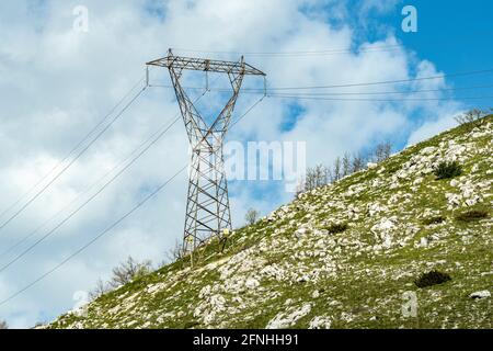 Mast der Hochspannungsleitung auf einem kargen Hügel. Abruzzen, Italien, Europa Stockfoto