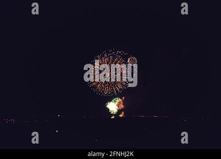 Erstaunliches Feuerwerk in dunklem Hintergrund isoliert mit dem Platz für Text Stockfoto