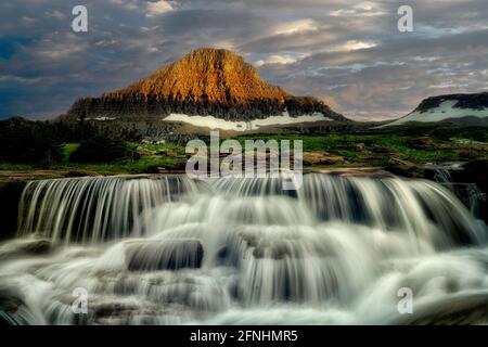 Reynolds Creek mit Spring Wasserfall am Creek bei Sonnenuntergang. Glacier National Park, Montanna Stockfoto