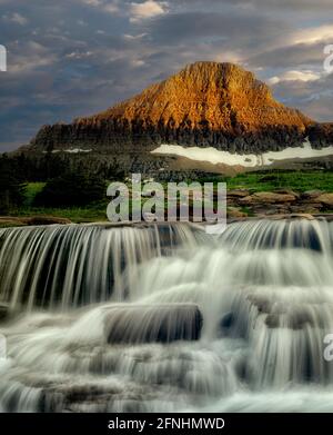 Reynolds Creek mit Spring Wasserfall am Creek bei Sonnenuntergang. Glacier National Park, Montanna Stockfoto