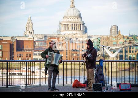 London, Großbritannien - 12. April 2019 - Straßenmusiker am Südufer mit der St. Paul's Cathedral im Hintergrund Stockfoto