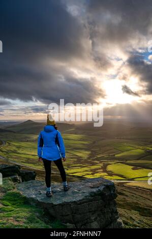 Weibliche Walkerin, die in Richtung Shutlingsloe mit dramatischem Himmel schaut, Shining Tor, Chashire Stockfoto