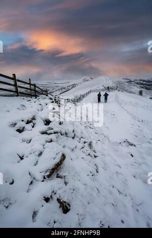 Wanderer im Schnee auf dem Great Ridge, die von Mam Tor, Derbyshire, in Richtung Losehill wandern Stockfoto