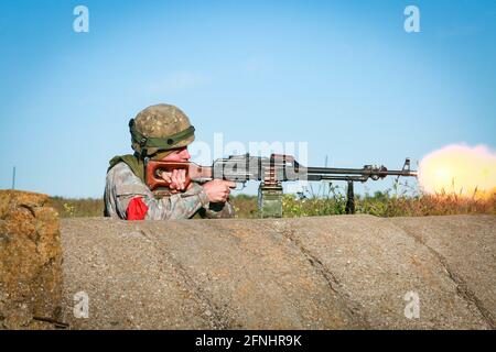 Ein rumänischer Soldat, der der 635. Artillerierestaat der 15. Brigade, 4. Division, zugewiesen wurde, feuert während der Übung Swift Response 21 ein leichtes Maschinengewehr im PKM-Stil auf dem Babadag Trainingsgelände, 15. Mai 2021 in Babadag, Rumänien. Stockfoto