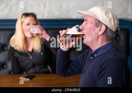 Gäste der Scotsman Lounge, Edinburgh, genießen einen Drink in der Bar. Alkohol kann jetzt in Pubs und Restaurants serviert werden, die bis 22.30 geöffnet bleiben dürfen, da Schottland die Beschränkungen der Stufe 2 einstellt, um die Sperre zu lockern. Stockfoto