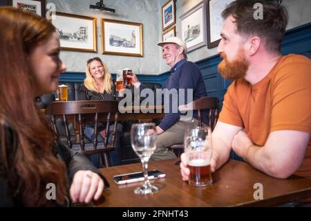 Gäste in der Scotsman Lounge, Edinburgh, genießen einen Drink in der Bar. Alkohol kann jetzt in Pubs und Restaurants serviert werden, die bis 22.30 geöffnet bleiben dürfen, da Schottland die Beschränkungen der Stufe 2 einstellt, um die Sperre zu lockern. Stockfoto