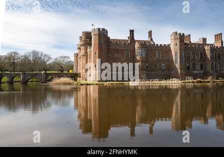 HERSTMONCEAUX, ENGLAND - 18. APRIL 2021: Schloss Hersmonceux spiegelt sich im Graben Stockfoto