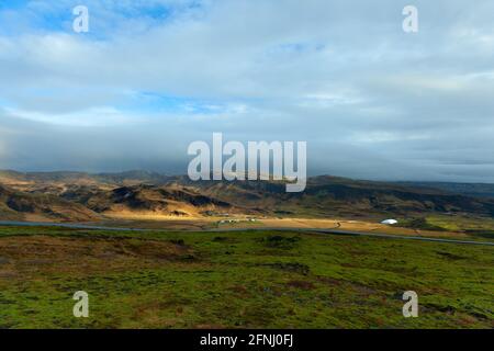 Gebiet in der Nähe von Hveragerdi mit von der Sonne beleuchteten Bergen, Südisland Stockfoto