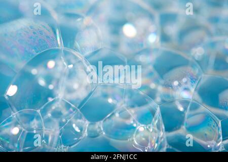 Schaumstoffhintergrund. Seifenblasen schließen sich auf blauem Hintergrund an. Stockfoto