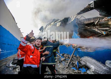 Palästinensische Feuerwehrleute reagieren, als sie ein Feuer auf eine Schwammfabrik auslösten, nachdem sie von israelischen Artilleriebünden getroffen wurde, inmitten der eskalierenden Eskalation der israelisch-palästinensischen Gewalt. Israel hat am Montag bei schweren Luftangriffen auf Gaza einen hochrangigen palästinensischen Kommandanten getötet und islamistische Gruppen haben trotz der zunehmenden internationalen Aufrufe zu einem Waffenstillstand erneut Raketenangriffe auf israelische Städte durchgeführt. (Foto von Ahmed Zakot / SOPA Images/Sipa USA) Stockfoto