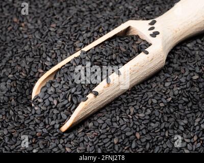 Holzlöffel in schwarzen Sesamkörnern aus nächster Nähe Stockfoto