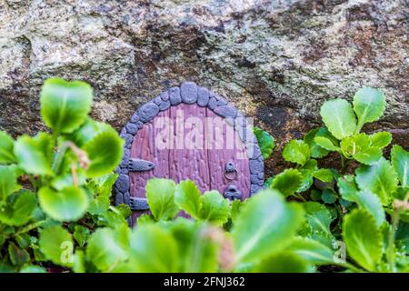 Versteckte Feenhaus Tür aus Ton in einer Wand Miniatur-Setup. Stockfoto