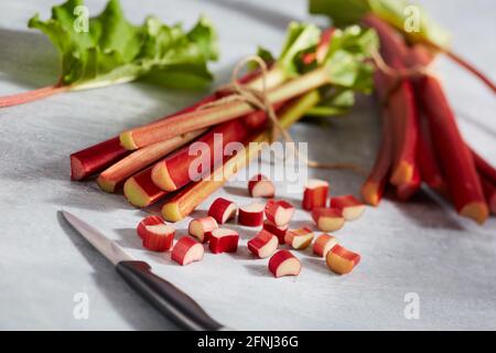 Rhabarber Stiele und schneiden Stücke auf grau rustikalen Metall Stockfoto