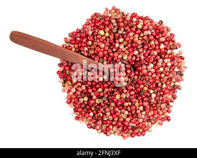Draufsicht auf Holzlöffel auf Haufen rosa Pfefferkörner (Baie Rose) auf weißem Hintergrund Stockfoto