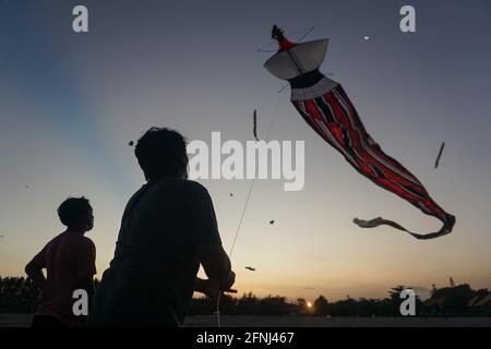 Denpasar, Indonesien. Mai 2021. Balinesische Jugendliche fliegen Drachen am Mertasari Beach, Sanur. Die Kitesaison findet jedes Jahr zwischen Mai und September während der Trockenzeit statt und ist die beste Zeit für einen Besuch im Tourismus auf Bali. Die Farben Rot, Weiß, Schwarz und Gold/Gelb repräsentieren die Inkarnationen der balinesischen Hindu-Gottheiten. (Foto von Dicky Bisinglasi/SOPA Images/Sipa USA) Quelle: SIPA USA/Alamy Live News Stockfoto