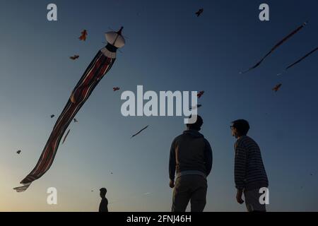 Denpasar, Indonesien. Mai 2021. Balinesische Jugendliche, die Flugdrachen am Mertasari Beach, Sanur, betrachten. Die Kitesaison findet jedes Jahr zwischen Mai und September während der Trockenzeit statt und ist die beste Zeit für einen Besuch im Tourismus auf Bali. Die Farben Rot, Weiß, Schwarz und Gold/Gelb repräsentieren die Inkarnationen der balinesischen Hindu-Gottheiten. (Foto von Dicky Bisinglasi/SOPA Images/Sipa USA) Quelle: SIPA USA/Alamy Live News Stockfoto