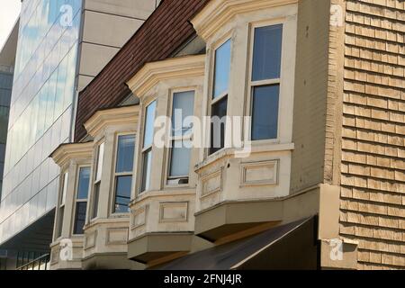 Reihe winkliger Erkerfenster eines hölzernen Mehrfamilienhauses in Vancouver, British Columbia, Kanada Stockfoto