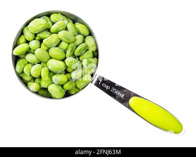 Draufsicht auf gefrorene Edamame (unreife Sojabohnen) Bei Messbecher Ausschnitt auf weißem Hintergrund Stockfoto