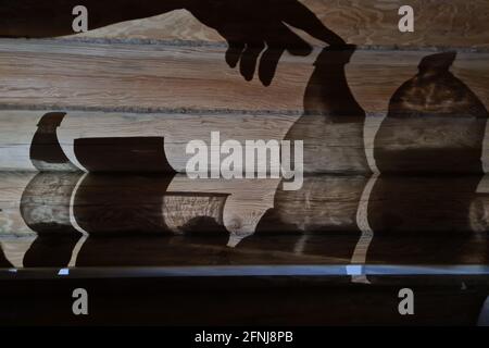 Schatten an der Wand mit weiblicher Hand und Utensilien Stockfoto