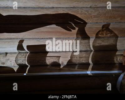 Schatten an der Wand mit weiblicher Hand und Utensilien Stockfoto