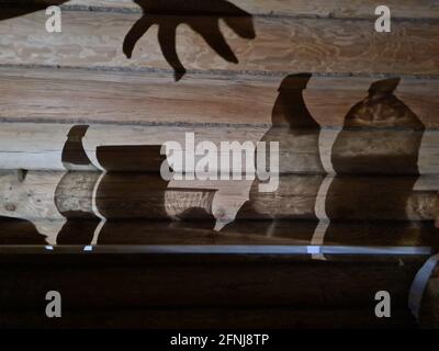 Schatten an der Wand mit weiblicher Hand und Utensilien Stockfoto