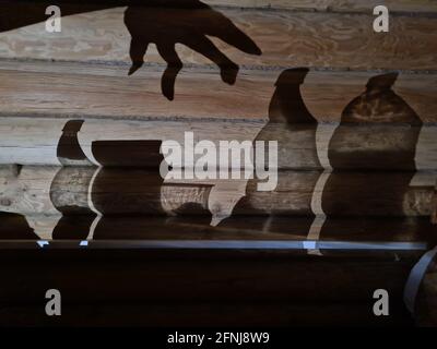 Schatten an der Wand mit weiblicher Hand und Utensilien Stockfoto