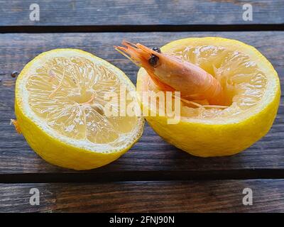 Königliche Garnelen mit Zitrone auf Holzboden Stockfoto