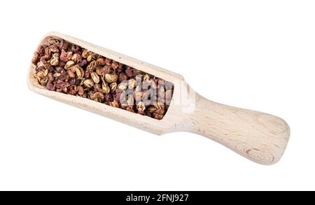 Draufsicht auf getrockneten rosafarbenen sichuanpfeffer in Holzlöffel Ausschnitt auf weißem Hintergrund Stockfoto
