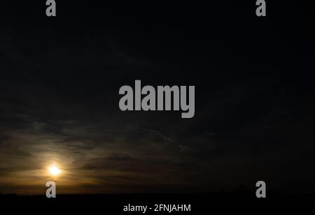 In diesem Bild des dunklen Himmels bei einem Sonnenuntergang in Iowa werden Wolken absichtlich weich fokussiert und als Hintergrund verwendet. Stockfoto