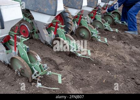 Farmer Checking ist die Traktorausrüstung, die für die Aussaat auf dem Feld bereit ist Im Frühling Stockfoto