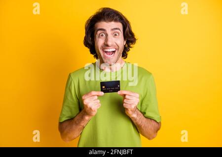 Portrait Foto von glücklichen Mann zeigt Bank Plastikkarte lächelnd Isoliert auf lebhaft gelbem Hintergrund Stockfoto