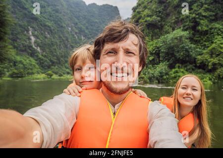 Glückliche Familien-Touristen in Trang an Scenic Landscape Complex in Ninh Binh Provinz, Vietnam EIN UNESCO-Weltkulturerbe. Wiederaufnahme des Tourismus in Stockfoto