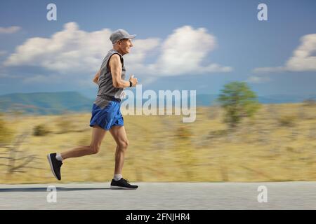 Ganzkörperaufnahme eines älteren Mannes beim Joggen Natur auf offener Straße Stockfoto