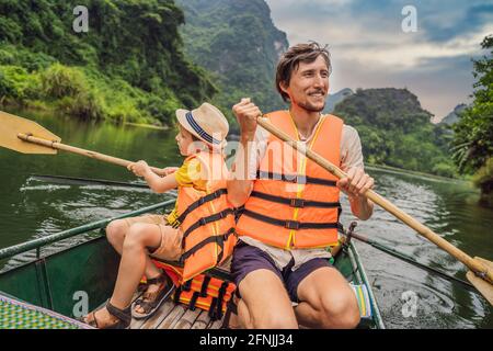 Glückliche Familien-Touristen in Trang an Scenic Landscape Complex in Ninh Binh Provinz, Vietnam EIN UNESCO-Weltkulturerbe. Wiederaufnahme des Tourismus in Stockfoto