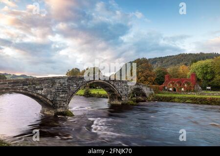 Der erste Morgengrauen über der Inigo Jones Bridge, dem Conwy River und dem TU Hwnt i’r Bont Tea Room, Llanwrst, Wales, Großbritannien Stockfoto