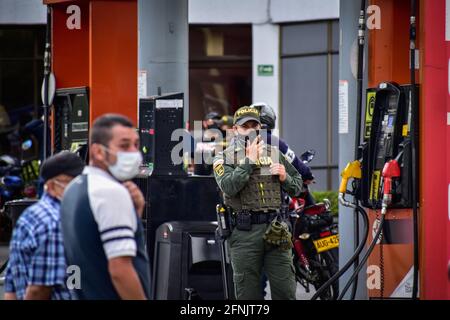 Pasto, Narino, Kolumbien. Mai 2021. Ein kolumbianischer Polizeibeamter, der eine Bulletprof-Weste verwendet, hilft, eine Tankstelle mit Mangel zu bewachen, inmitten massiver Kraftstoffengpässe aufgrund der Zunahme von Protesten in Kolumbien gegen Polizeibrutalität und Missbrauchsfälle, die in den letzten 20 Tagen zu 16 misshandelten Frauen und mehr als 40 Toten führen Regierungsfeindlicher nationaler Streik, in Pasto, Narino am 16. Mai 2021 Quelle: Camilo Erasso/LongVisual/ZUMA Wire/Alamy Live News Stockfoto