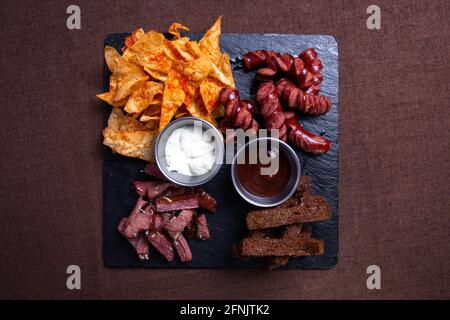 Snacks zu Bier in der Bar, Wurst, Fleisch und Cracker mit Chips. Stockfoto