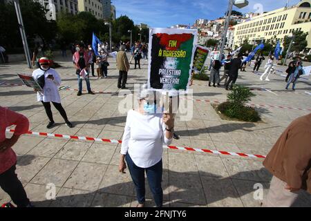 Lissabon, Portugal. Mai 2021. Ein Demonstranten trägt ein Protestplakat während einer Kundgebung in Lissabon gegen die Einmischung Israels. Die Kundgebung für „Solidarität mit Palästina“ fand auf dem Martim Moniz-Platz in der portugiesischen Hauptstadt statt und wurde vom portugiesischen Rat für Frieden und Zusammenarbeit (CPPC) organisiert. Die Bewegung für die Rechte des palästinensischen Volkes und für den Frieden im Nahen Osten (MPPM) und der Allgemeine Verband der portugiesischen Arbeitnehmer - Nationale Gewerkschaft (CGTP-IN). Kredit: SOPA Images Limited/Alamy Live Nachrichten Stockfoto