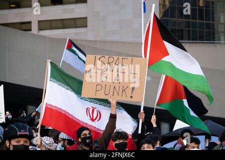 Pro-palästinensische Demonstranten verurteilen Israel, während sie bei einer anti-israelischen Veranstaltung in Toronto, Kanada, palästinensische und iranische Regime-Flaggen schwenken. Stockfoto