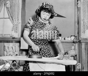 Ester Naite, Bügeln von Kleidung, Manzanar Relocation Center, Kalifornien, USA, Dorothea lange, U.S. war Relocation Authority, April 1942 Stockfoto