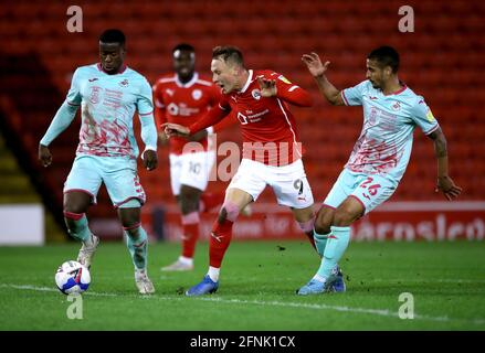 Barnsley's Cauley Woodrow (Mitte) kämpft mit Marc Guehi (links) und Kyle Naughton aus Swansea City während des Halbfinales der Sky Bet Championship, des First Leg Matches im Oakwell Stadium, Barnsley, um den Ball. Bilddatum: Montag, 17. Mai 2021. Stockfoto