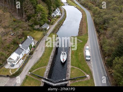 Eine Yacht durchläuft das Schleusensystem am Crinan-Kanal in der Nähe des Dorfes Cairnbaan in Argyll & Bute, Schottland, Großbritannien Stockfoto