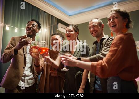 Eine vielfältige Gruppe von fröhlichen jungen Menschen, die eine Brille halten und schauen Auf dem Bildschirm, während Sie Online-Partys mit Freunden genießen Stockfoto
