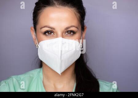 Junge Ärztin, Krankenschwester mit Schutzmaske. Isoliert auf grauem Hintergrund. Breites Bannerformat Stockfoto