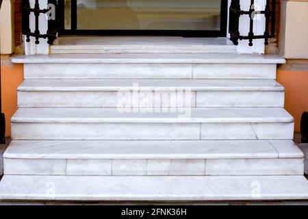 Weiße Marmortreppe mit Steintreppe an der Schwelle des Ladeneingangs mit Glastür Nahaufnahme der Architektur, niemand. Stockfoto