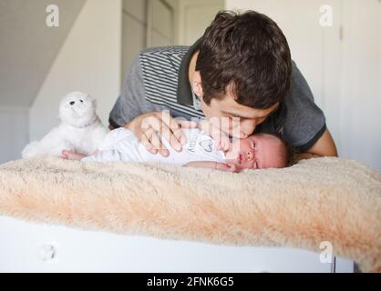 Vater küsst kleinen neugeborenen Sohn Stockfoto