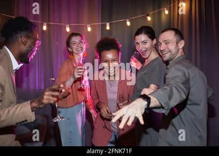 Eine Gruppe von sorglosen Menschen, die zu Hause tanzen, während sie Party genießen, aufgenommen mit Blitz Stockfoto