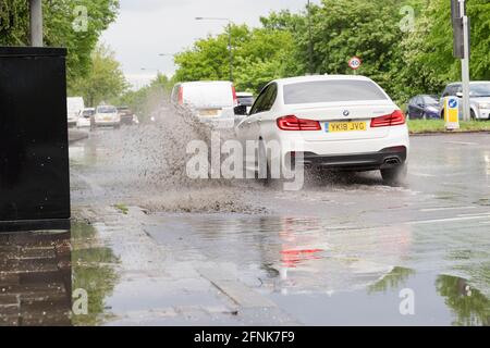 Weißer BMW macht Splash von Sturzflut auf der südlichen Kreisstraße, Greater London, England Stockfoto